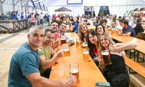 Amigos brindando con jarras de cerveza en el oktober valdespartera. Ambiente festivo y sonrisas.