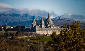 Impresionante Monasterio de El Escorial, un lugar clave que ver en la Comunidad de Madrid, con montañas nevadas al fondo.