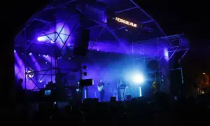 Escenario iluminado con luces azules para un concierto en la Estación del Norte de Zaragoza durante las Fiestas del Pilar.