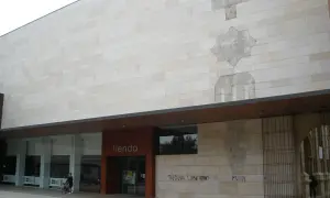 Fachada del centro de historias Zaragoza, con una tienda y grafitis.