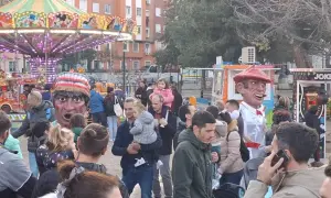 Gigantes y cabezudos animan las fiestas San José Zaragoza. Un carrusel y puestos de feria completan la escena festiva.