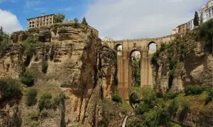 Impresionante puente de piedra sobre un profundo desfiladero, uno de los puentes de España más icónicos. Edificios en lo alto de los acantilados.