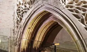 Detalle arquitectónico de un arco gótico en el museo Alma Mater, con ladrillo expuesto y ornamentación de piedra calada.