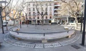 Banqueta circular de piedra en la plaza San Pedro Nolasco Zaragoza, con árboles desnudos y edificios al fondo.