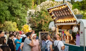 Gente disfrutando en un programa food truck Zaragoza, con un camión de comida iluminado y lleno de gente esperando.