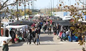 Gente paseando y comprando en un bullicioso mercadillo al aire libre cerca del auditorio de Zaragoza.