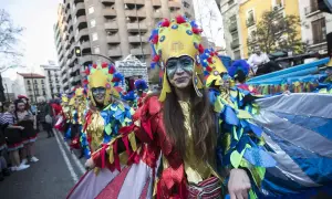 Gente disfrazada con trajes coloridos y elaborados desfila en los carnavales de Zaragoza, celebrando con alegría y arte.