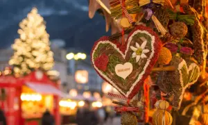 Corazón decorado con "Welcome" en un mercadillo navideño de Calatayud. Luces de árbol y puestos de feria al fondo.