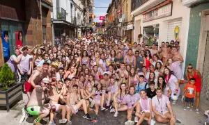 Multitud celebrando las fiestas de Zuera, con gente sonriendo y posando para la foto en una calle.