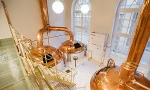 Cata de cervezas Zaragoza: Cobre brillante y escaleras metálicas en una cervecería tradicional.