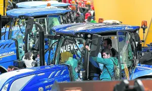Tractores New Holland en la FIMA Zaragoza 2026. Personas observan los nuevos modelos, algunos niños curiosos se asoman.