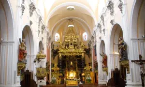 Interior de la iglesia san felipe zaragoza, con bancos de madera, un retablo dorado y estatuas de santos.