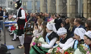 Presentación del programa fiestas delicias con un hombre enmascarado y público atento.