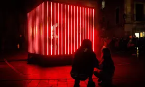 Dos personas observan una instalación de luces rojas en Zaragoza, un adelanto de lo que Zaragoza luce 2026.