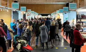 Gente disfrutando de la feria artesanía Zaragoza, con puestos de juegos, arte y bolsos.