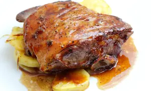 Ternasco asado jugoso y dorado, servido sobre patatas. ¡La mejor opción donde comer ternasco en Zaragoza!