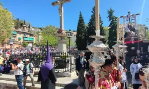 Procesiones Semana Santa Viernes Santo en Granada. Nazarenos con túnicas moradas y pasos procesionales iluminados por velas.