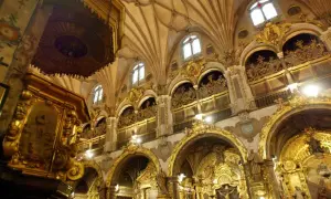 Interior del real seminario de San Carlos, con altares dorados, arcos ornamentados y techos abovedados.