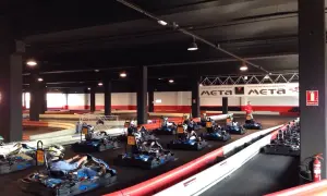 Carreras de **karting Puerto Venecia**. Varios karts listos en la pista, algunos con pilotos preparándose para la acción.
