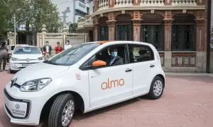 Un hombre con mascarilla conduce un coche blanco de carsharing en Zaragoza.