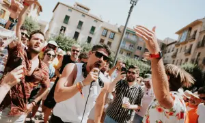 Un cantante con micrófono anima a la multitud en un festival. Gente con pulseras de acceso, un verdadero amante festival.