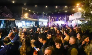 Multitud disfrutando de food trucks Zaragoza Pilares bajo luces festivas.