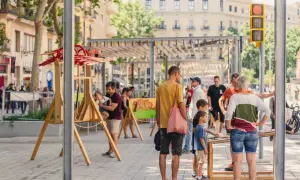 Gente disfrutando de unas vacaciones con niños en Cataluña, con juegos y actividades al aire libre en una calle peatonal.