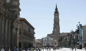 Plaza del Pilar en Zaragoza, con la imponente iglesia de la Seo y el Ayuntamiento. Gente paseando bajo el sol.