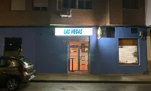 Fachada de "Las Vegas" en Zaragoza, con un coche aparcado y la calle mojada.