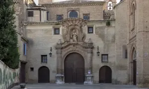 Fachada de la iglesia de las canonesas del Santo Sepulcro, con su gran portalón de madera y una escultura en el nicho central.