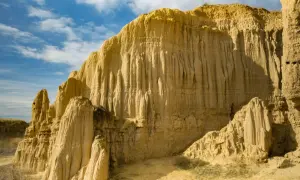 Formaciones rocosas erosionadas que recuerdan a la **Capadocia aragonesa** bajo un cielo azul con nubes.