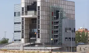 Edificio crea con fachada de paneles cuadrados y una escalera exterior metálica.