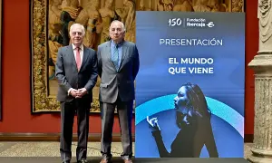 Dos hombres de traje posan ante un cartel de Fundación Ibercaja que anuncia "El mundo que viene", en un evento de martes de libros Ibercaja.
