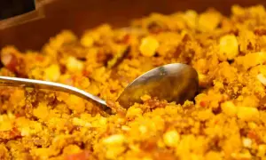 Migas aragonesas, un plato tradicional con trozos de pan, huevo y chorizo, listo para servir con una cuchara.
