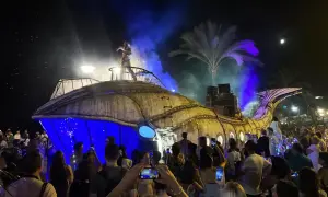 Una gran ballena mecánica ilumina la noche en una fiesta de los 90 en Zaragoza. El público, con móviles en mano, celebra el espectáculo.