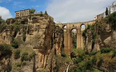Impresionante puente de piedra sobre un profundo desfiladero, uno de los puentes de España más icónicos. Edificios en lo alto de los acantilados.