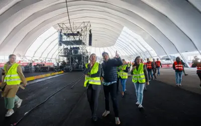 Gente con chalecos fluorescentes revisa montaje en carpa para ferias Valdespartera. Así se llega al evento.