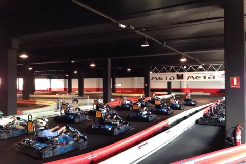 Carreras de **karting Puerto Venecia**. Varios karts listos en la pista, algunos con pilotos preparándose para la acción.