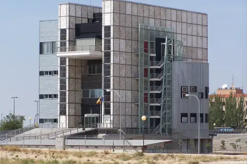 Edificio crea con fachada de paneles cuadrados y una escalera exterior metálica.
