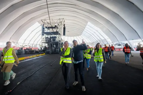 Gente con chalecos fluorescentes revisa montaje en carpa para ferias Valdespartera. Así se llega al evento.