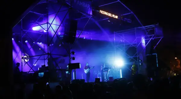 Escenario iluminado con luces azules para un concierto en la Estación del Norte de Zaragoza durante las Fiestas del Pilar.