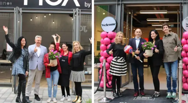 Inauguración de tienda en marketches torre outlet. Gente sonriente celebra la apertura con globos rosas y plantas.