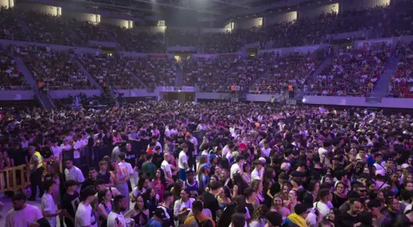 Multitud vibrante en el Pabellón Príncipe Felipe para disfrutar de conciertos. El recinto está lleno de gente, creando un ambiente festivo.