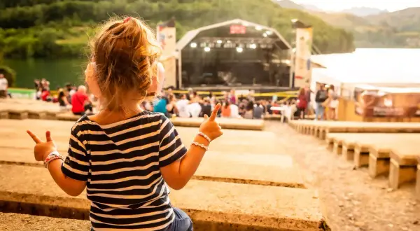 Niña emocionada en el concierto ZAZ Pirineos Sur, disfrutando la música al aire libre.