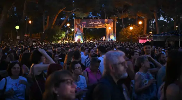 Multitud disfrutando de música al raso Zaragoza bajo un arco de agradecimiento.
