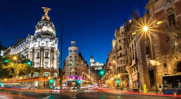 Noche en Gran Vía, Madrid. Edificios iluminados y luces de coches crean un ambiente vibrante. Un lugar ideal que ver en Madrid centro.