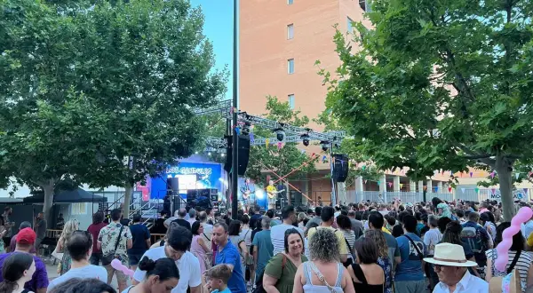 Multitud disfrutando de las fiestas rosales del canal, con un concierto de "Los Gandules" en el escenario.