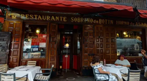 Fachada del restaurante Sobrino de Botín, el restaurante más antiguo de España, con mesas puestas en el exterior.