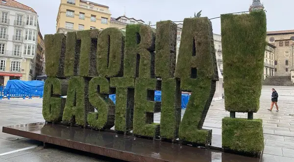 Letras gigantes cubiertas de césped con "VITORIA-GASTEIZ" en una plaza. ¡Un lugar genial que ver en Vitoria!