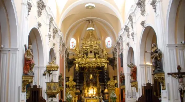 Interior de la iglesia san felipe zaragoza, con bancos de madera, un retablo dorado y estatuas de santos.